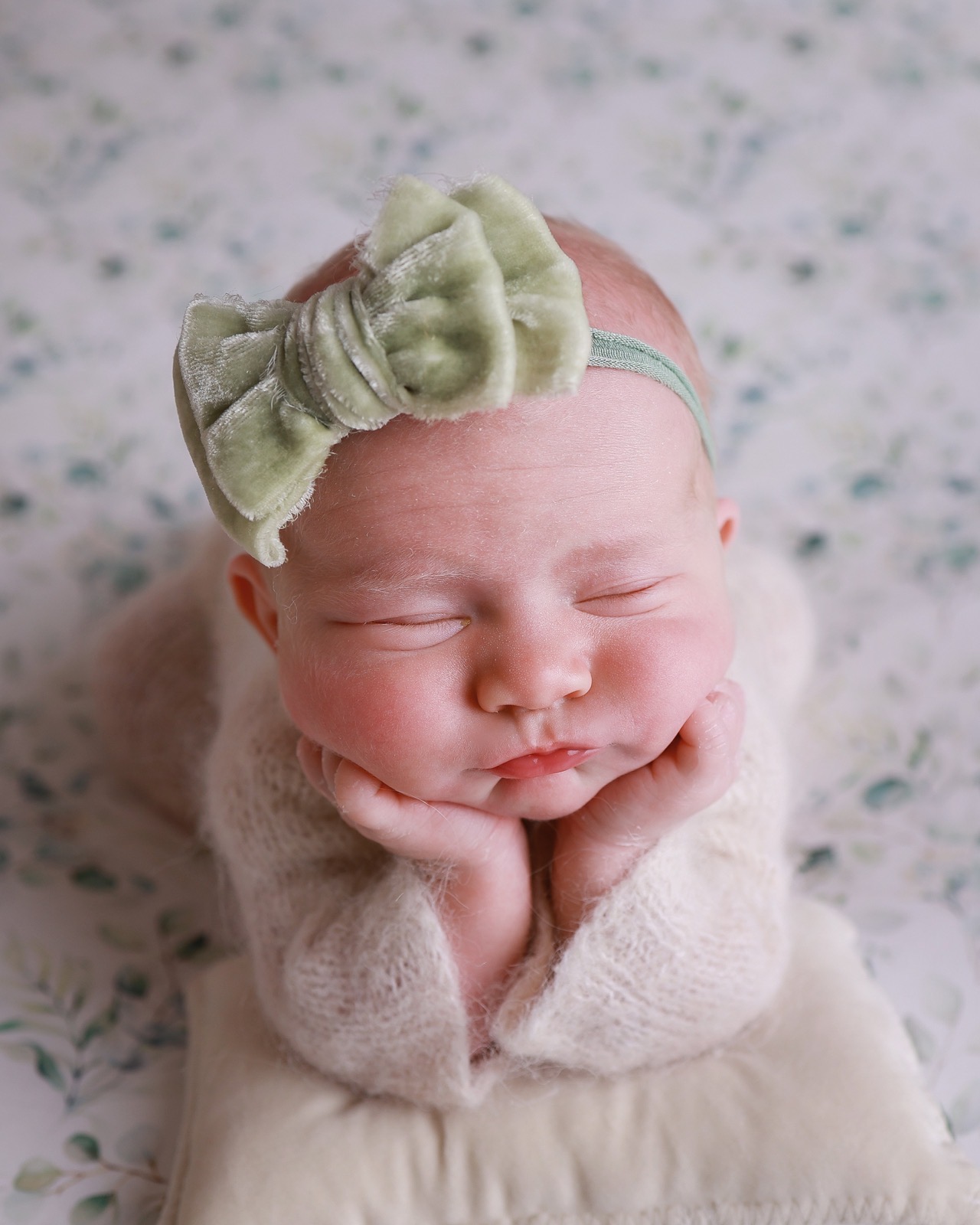 Sleeping newborn resting her chin on her hands, sage green velvet bow headband