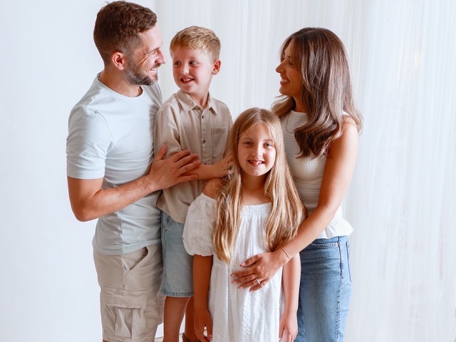 Family of four smiling together, from a family photography session