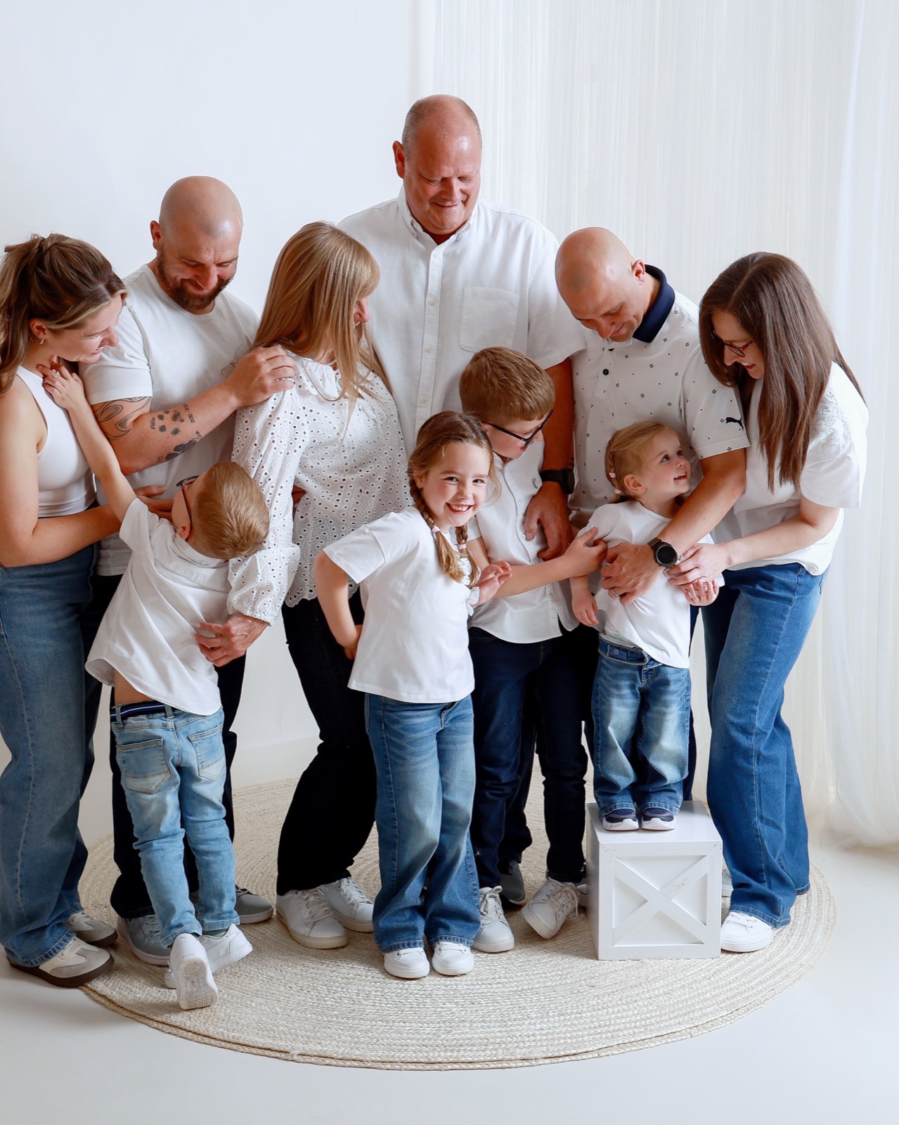 Large extended family in matching white outfits, gathered close together