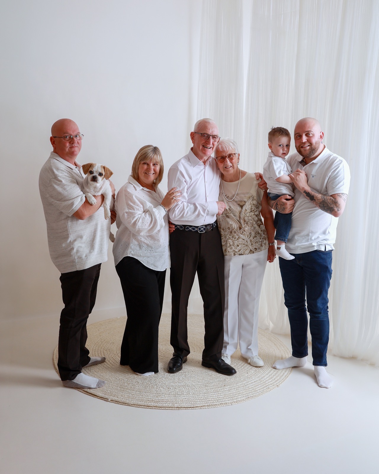 Extended family of five in another pose, with a toddler boy held by one of the sons