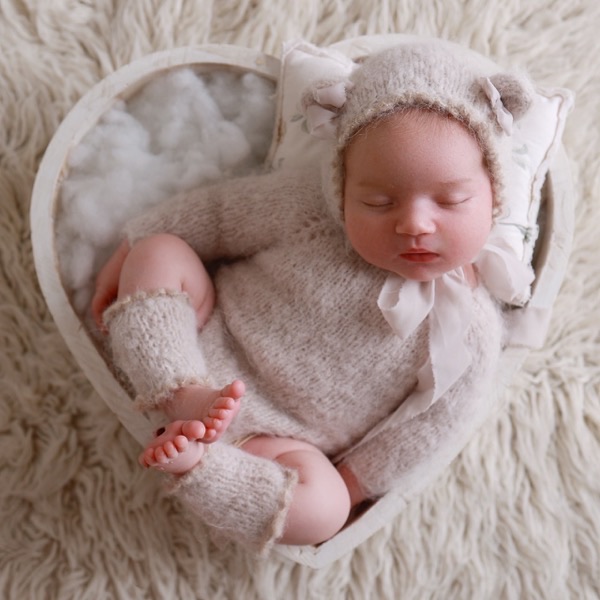 Newborn asleep in a heart-shaped basket, one of many photos delivered from a single baby session