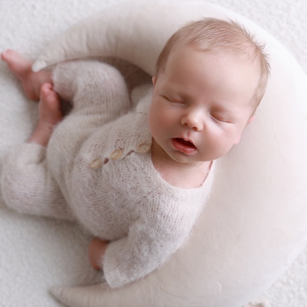 Newborn asleep on a crescent moon cushion, from the same session