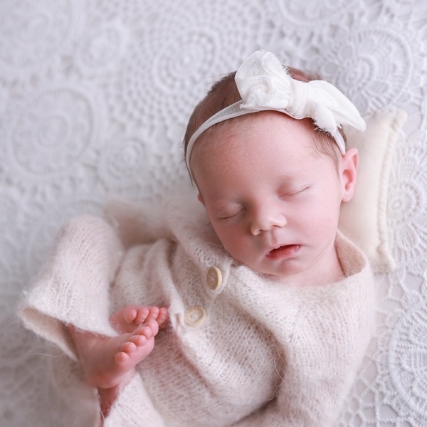 Newborn asleep on a lace blanket, from the same session