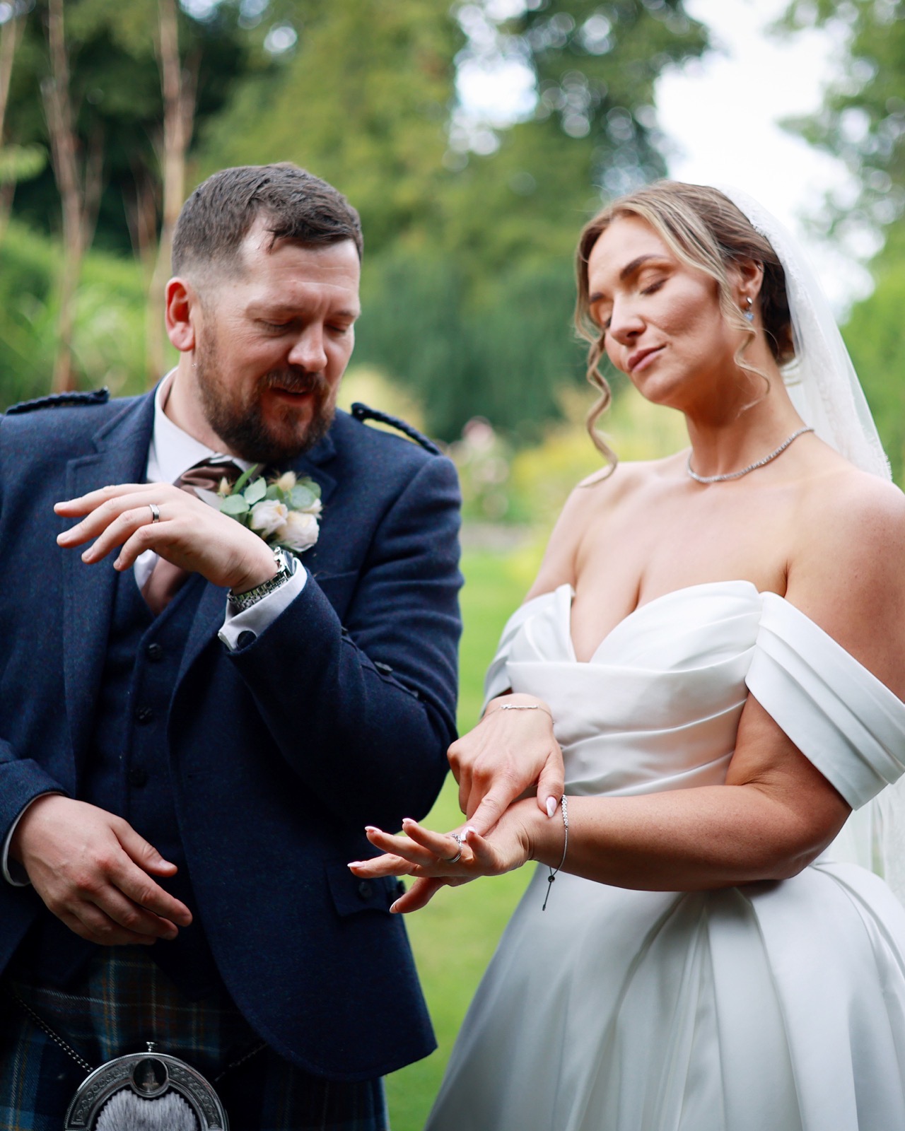 Groom checking his watch as the bride looks at her hand, both playful